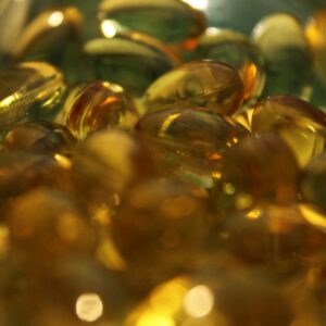 a glass bowl filled with lots of yellow and green pills