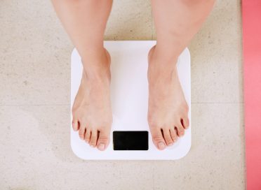 person standing on white digital bathroom scale